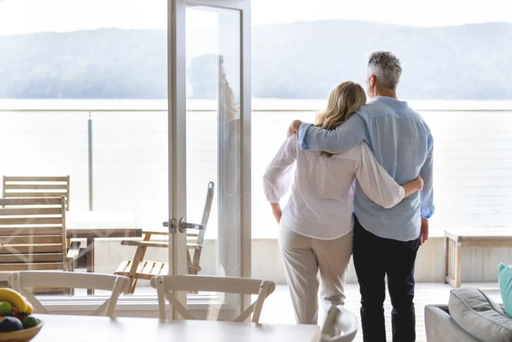 Mature couple looking at the view in their waterfront home