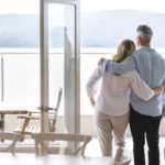 Mature couple looking at the view in their waterfront home