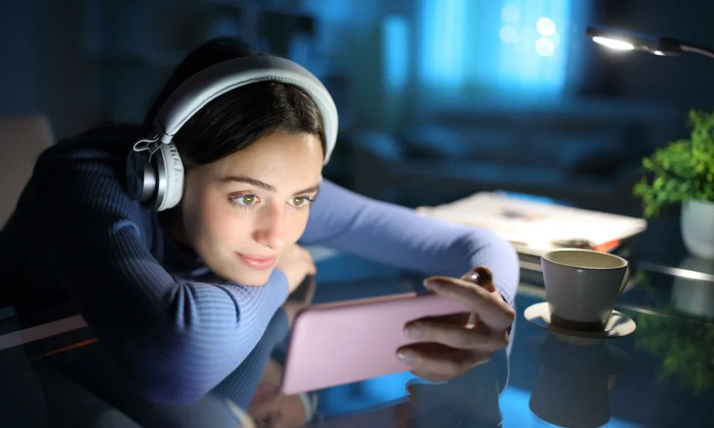 Woman watching media on smart phone in the night at home