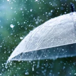 Transparent umbrella under rain against water drops splash background. Rainy weather concept.