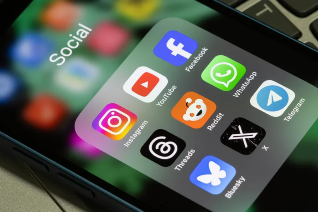 Portland, OR, USA - Aug 5, 2025: Assorted popular social media apps, including Instagram, YouTube, Facebook, Threads, Reddit, WhatsApp, Bluesky, X, and Telegram, are seen on the screen of an iPhone.