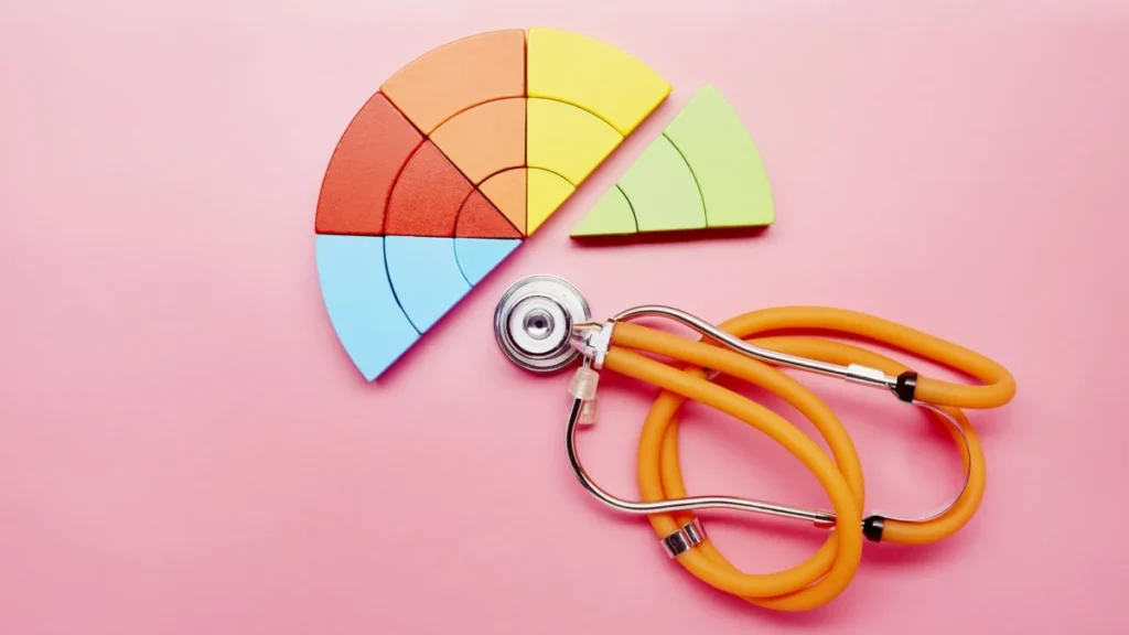 High angle view of a pie chart made of colorful building blocks and orange stethoscope
