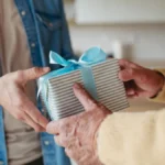 Close up of mature son bringing gift for Father’s day for his dad. Eternal love for parent and fatherly love.