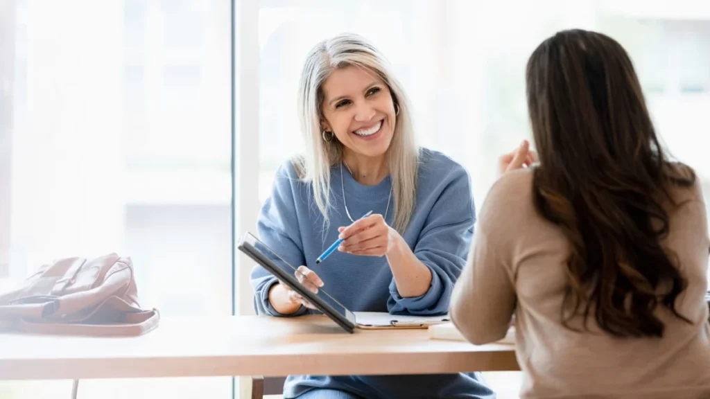 Mature female financial advisor meets with unrecognizable female client