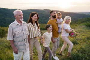 Multi generation family walking in nature at sunset