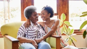 Senior woman and her daughter smiling at each other during a visit