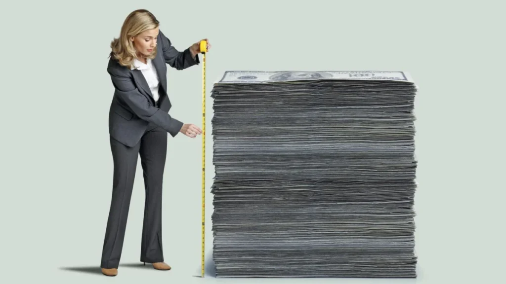 Woman Measuring Stack Of Money