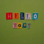 Hello 2027 message with colorful cutout letters on green background
